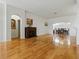 Large living room showcasing hardwood floors, a cozy fireplace, and seamless transition to the dining area at 3001 Lake Huron Ln, Tavares, FL 32778