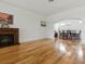 Spacious living room features wood floors, a cozy fireplace, and an open layout to the dining area at 3001 Lake Huron Ln, Tavares, FL 32778