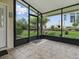 Screened-in patio with tile floors overlooking a manicured lawn and landscaped gardens at 3001 Lake Huron Ln, Tavares, FL 32778