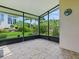 Screened-in patio overlooking a landscaped backyard with lush greenery and blooming flowers at 3001 Lake Huron Ln, Tavares, FL 32778