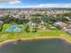 Expansive aerial view showcasing the community, tennis courts, lush landscaping, and serene lake at 310 Ballyshannon Dr, Davenport, FL 33897
