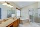 Well-lit bathroom featuring a shower, tub, and vanity providing a relaxing experience at 310 Ballyshannon Dr, Davenport, FL 33897