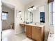 Bright bathroom features a vanity with wooden cabinets, a large mirror, and access to the commode at 310 Ballyshannon Dr, Davenport, FL 33897