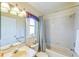 The bathroom has a shower-tub combo, a cream colored vanity, and neutral colored tile at 310 Ballyshannon Dr, Davenport, FL 33897