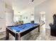 Bright game room with a pool table, direct view of the dining room, and light gray walls at 310 Ballyshannon Dr, Davenport, FL 33897