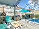 Covered patio featuring an outdoor kitchen with pizza oven, grill, sink, and dining area next to the pool at 310 Ballyshannon Dr, Davenport, FL 33897