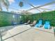 Spacious screened-in patio area with lounge chairs, artificial greenery and cozy decorative elements at 310 Ballyshannon Dr, Davenport, FL 33897