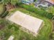 Overhead shot of a sand volleyball court surrounded by trees and lush landscaping at 310 Ballyshannon Dr, Davenport, FL 33897