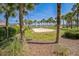 A sand volleyball court framed by palm trees and lush greenery at 310 Ballyshannon Dr, Davenport, FL 33897