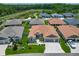 An aerial view of a neighborhood with houses and manicured lawns near a pond at 3138 Aurea Pl, The Villages, FL 32163