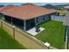 A view of the back of the home with a screened lanai, concrete patio, barbecue, and fenced yard at 3138 Aurea Pl, The Villages, FL 32163