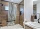 Bathroom features wood-look tile shower, sleek black fixtures, and marble countertop vanity at 3138 Aurea Pl, The Villages, FL 32163