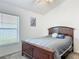 Cozy bedroom with a wood bed frame, plush carpeting, and a bright window bringing in natural light at 3138 Aurea Pl, The Villages, FL 32163
