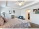 Bright bedroom features tray ceilings, ceiling fan, and a cozy sitting area with blue chair at 3138 Aurea Pl, The Villages, FL 32163