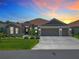 Beautiful home with a three-car garage and well-manicured lawn at sunset at 3138 Aurea Pl, The Villages, FL 32163