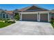A house with a well-manicured lawn, a long driveway, and a three-car garage at 3138 Aurea Pl, The Villages, FL 32163