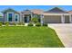 Well-maintained single-story home with a three-car garage and lush green lawn at 3138 Aurea Pl, The Villages, FL 32163