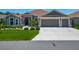 Well-maintained single-story home with a three-car garage and lush green lawn at 3138 Aurea Pl, The Villages, FL 32163