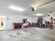 Organized garage with tool chest, storage shelves, and space for multiple vehicles at 3138 Aurea Pl, The Villages, FL 32163