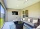 Cozy screened patio with stylish furniture and a mounted TV at 3138 Aurea Pl, The Villages, FL 32163