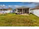Spacious backyard with grass, white fence, patio, outdoor furniture, and playset at 3194 Bayou Ln, Tavares, FL 32778