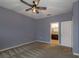 Bedroom featuring neutral carpet, gray walls, ceiling fan, and open doorway to a bathroom at 3194 Bayou Ln, Tavares, FL 32778