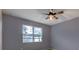 Cozy bedroom with a ceiling fan, window with blinds, and neutral-colored walls at 3194 Bayou Ln, Tavares, FL 32778