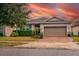 Charming single-Gathering home with a brick driveway, landscaping, and beautiful sunset sky at 3194 Bayou Ln, Tavares, FL 32778