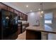 Modern kitchen with stainless steel appliances, dark wood cabinets, and a granite countertop island at 3194 Bayou Ln, Tavares, FL 32778