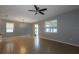 Spacious living room with tile flooring, a ceiling fan, and natural light from sliding glass doors at 3194 Bayou Ln, Tavares, FL 32778