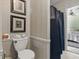 Bathroom featuring a toilet, blue shower curtain, and framed prints on the wall at 32521 W Golf Ct, Leesburg, FL 34748
