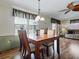 A cozy dining area features wood floors, natural light, and a transitional chandelier at 32521 W Golf Ct, Leesburg, FL 34748
