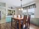This dining area has a wooden table, stylish chandelier, and a view into the kitchen at 32521 W Golf Ct, Leesburg, FL 34748
