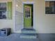 Inviting home entrance with a vibrant green door and decorative steps at 32521 W Golf Ct, Leesburg, FL 34748