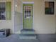 Inviting home entrance with a vibrant green door and decorative steps at 32521 W Golf Ct, Leesburg, FL 34748