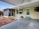 Home exterior features a screen enclosed porch, covered patio, and meticulous landscaping at 32521 W Golf Ct, Leesburg, FL 34748