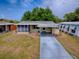 Charming mobile home featuring a covered entrance and a concrete driveway at 32521 W Golf Ct, Leesburg, FL 34748