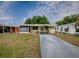 Inviting home with a screen enclosed porch, concrete driveway, green shutters, and well-manicured landscaping at 32521 W Golf Ct, Leesburg, FL 34748