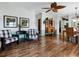 Open-concept living room with laminate floors, charming decor, and lots of natural light at 32521 W Golf Ct, Leesburg, FL 34748