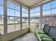 Sunroom with multiple windows and slate tile flooring, and cushioned wicker furniture at 32521 W Golf Ct, Leesburg, FL 34748