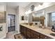 Elegant bathroom with double sink vanity, large mirror, and access to walk-in closet at 3677 Arlington Ridge Blvd, Leesburg, FL 34748