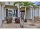 Inviting front entrance with decorative glass door, stone accents, and lush tropical landscaping with palms at 3677 Arlington Ridge Blvd, Leesburg, FL 34748