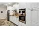 Bright kitchen features white cabinetry, stainless steel appliances, and patterned backsplash at 3677 Arlington Ridge Blvd, Leesburg, FL 34748