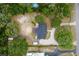Aerial view of a well-treed lot featuring a charming home with a circular pool and long driveway at 39812 French Rd, Lady Lake, FL 32159