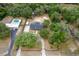 Aerial view of lush property featuring a beautiful home, circular driveway, large pool, and mature trees at 39812 French Rd, Lady Lake, FL 32159