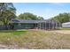 Spacious backyard with a screened-in patio and lush green lawn, ideal for outdoor activities and relaxation at 39812 French Rd, Lady Lake, FL 32159