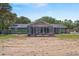 Green exterior, expansive lawn and screened in back porch with outdoor furniture, perfect for outdoor entertainment at 39812 French Rd, Lady Lake, FL 32159