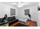 Bedroom with hardwood floors, gray curtains, and a dark-colored sofa, perfect for relaxing and entertaining at 39812 French Rd, Lady Lake, FL 32159