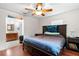 Well-lit primary bedroom boasts hardwood floors, ceiling fan and en-suite bathroom at 39812 French Rd, Lady Lake, FL 32159