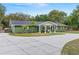 Well-maintained single-story home showcasing a spacious driveway and lush greenery, enhancing its curb appeal at 39812 French Rd, Lady Lake, FL 32159